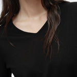 Close-up portrait of black cotton blend v neck knit top by Mijeong Park showing v neckline and knit texture