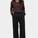 Full look of brown cotton blend v neck knit top by Mijeong Park with relaxed fit and black wide leg pants