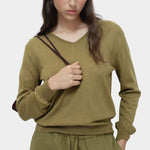 Green cotton blend v neck knit top by Mijeong Park with relaxed fit styled with matching knit pants