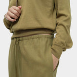 Close-up of green cotton blend v neck knit top by Mijeong Park with rib hem and drawstring knit pants