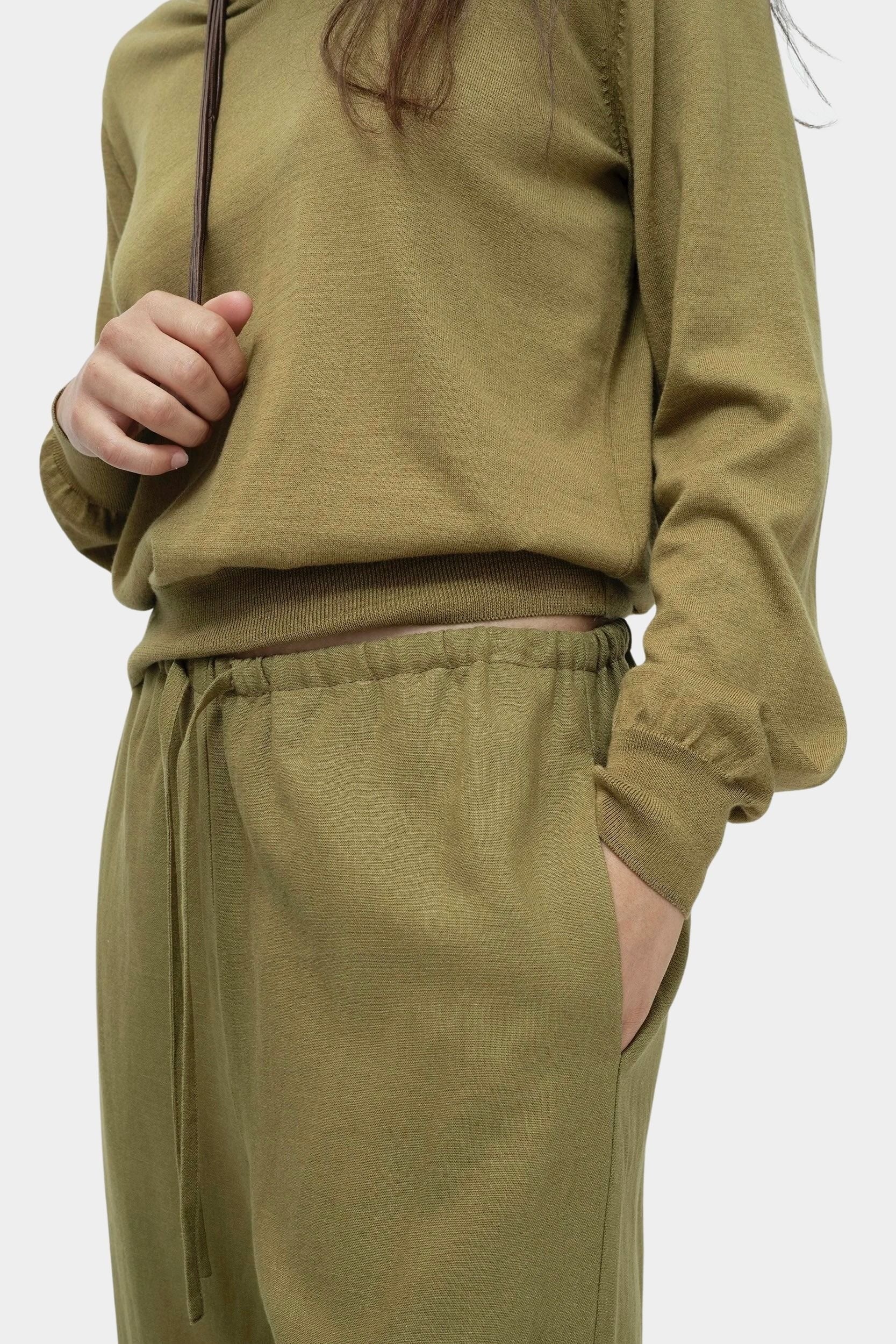 Close-up of green cotton blend v neck knit top by Mijeong Park with rib hem and drawstring knit pants