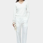Full look of white cotton blend v neck knit top by Mijeong Park styled with white trousers and sandals