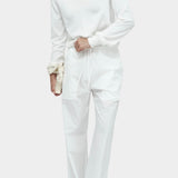 White cotton blend v neck knit top by Mijeong Park styled with white wide leg trousers