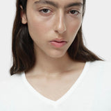Close-up of white cotton blend v neck knit top by Mijeong Park showing v neckline and knit texture