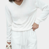 White cotton blend v neck knit top by Mijeong Park with relaxed fit styled with white drawstring trousers