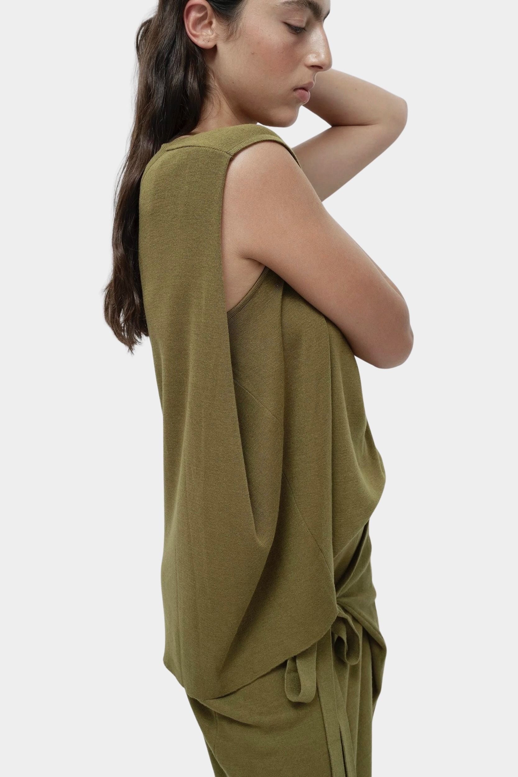 Side profile green drape back knit top by Mijeong Park with fluid sleeveless silhouette and back drape