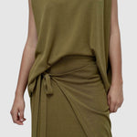 Detail view green drape back knit top by Mijeong Park showing soft knit texture and draped waist tie styling