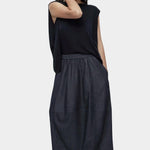 Full outfit navy drape back knit top by Mijeong Park styled with dark skirt