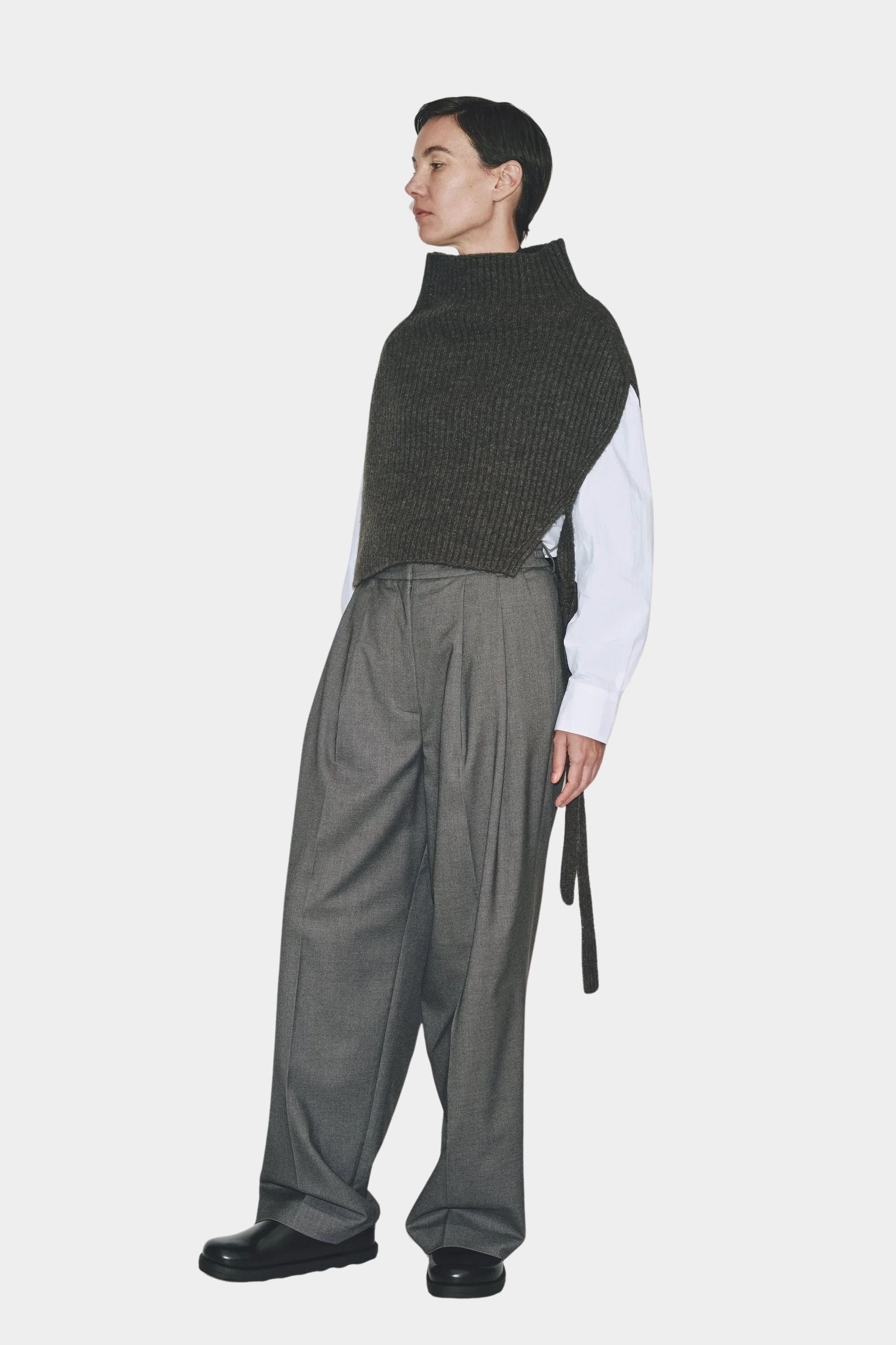 Full look charcoal knit neck warmer with pleated trousers and loafers