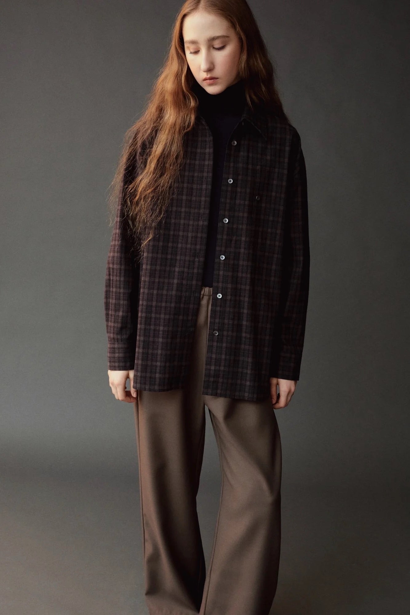 Front view of the Mijeong Park black plaid oversized shirt layered over a black turtleneck