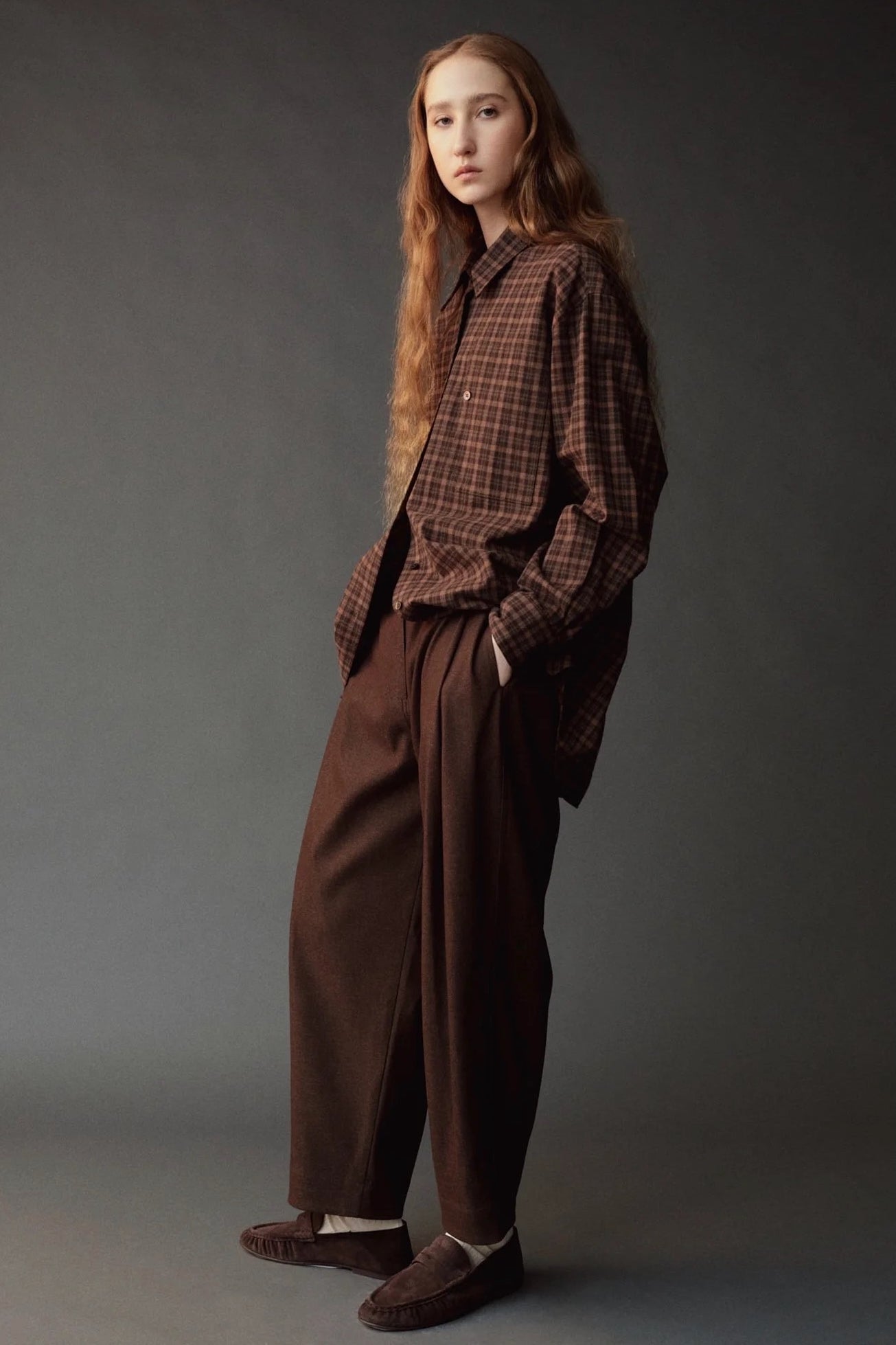 Angled view of the Mijeong Park Oversized Plaid Shirt showing its relaxed fit and long sleeves