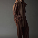Side view of the Mijeong Park brown plaid shirt layered beneath a draped brown knit