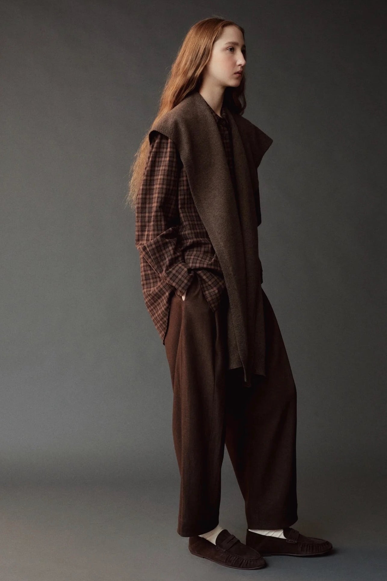 Side view of the Mijeong Park brown plaid shirt layered beneath a draped brown knit