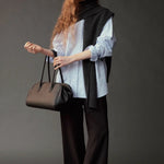 Front view of the Mijeong Park light blue oversized shirt styled with a charcoal knit and handbag