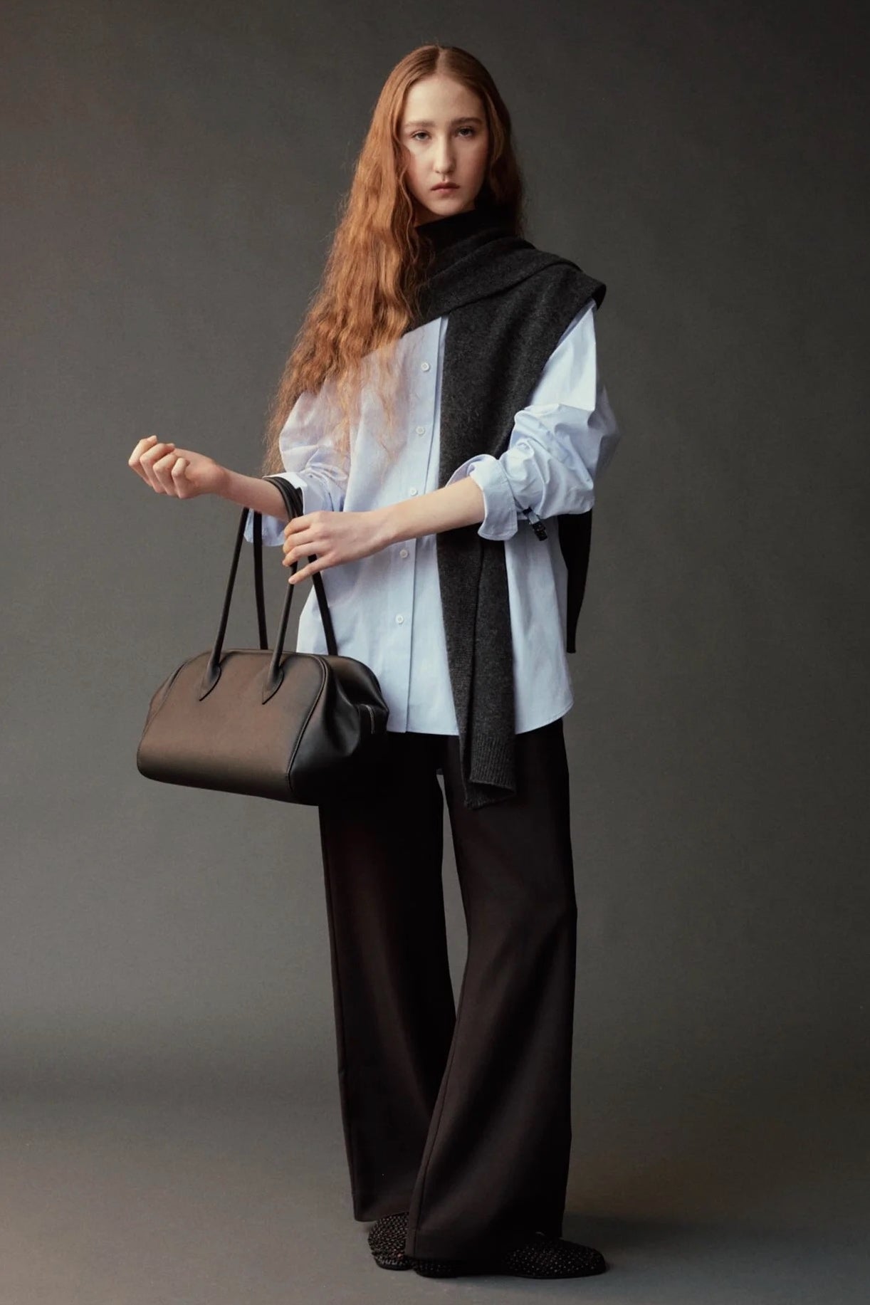 Front view of the Mijeong Park light blue oversized shirt styled with a charcoal knit and handbag