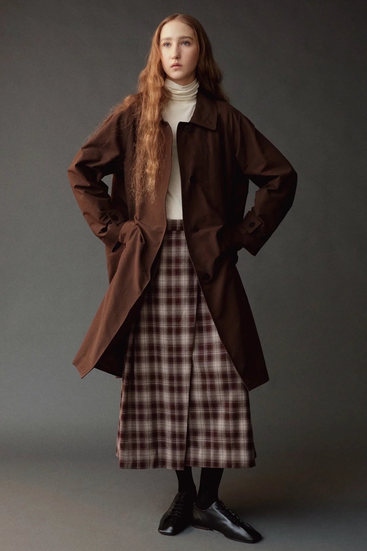 Mijeong Park brown plaid midi skirt styled with an oversized brown coat and ivory turtleneck