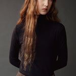 Close up of the dark navy roll neck jersey top showing its fitted silhouette.