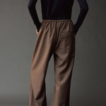 Back view of the dark navy roll neck jersey top styled with wide leg brown pants.