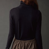 Close back view of the dark navy roll neck jersey top with slim long sleeves.