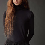 Close up of the graphite roll neck jersey top showing its softly gathered neckline.