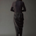 Graphite roll neck jersey top styled with a draped charcoal skirt and tights.