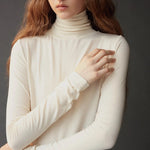 Close up of the ivory roll neck jersey top showing its softly gathered neckline.