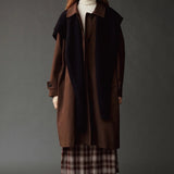 Ivory roll neck jersey top layered under a brown coat with a dark scarf.