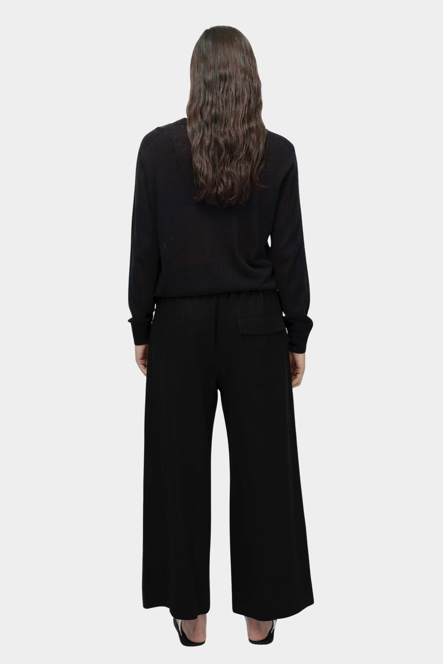 Back view of semi sheer linen blend knit top in black by Mijeong Park with relaxed lightweight fit
