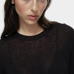 Close-up of semi sheer black linen blend knit top by Mijeong Park with crew neckline and sheer knit fabric