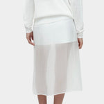 Back view of semi sheer linen blend knit top in white by Mijeong Park paired with sheer midi skirt