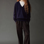 Front view of the Mijeong Park black wool blend pants styled with a navy V neck sweater