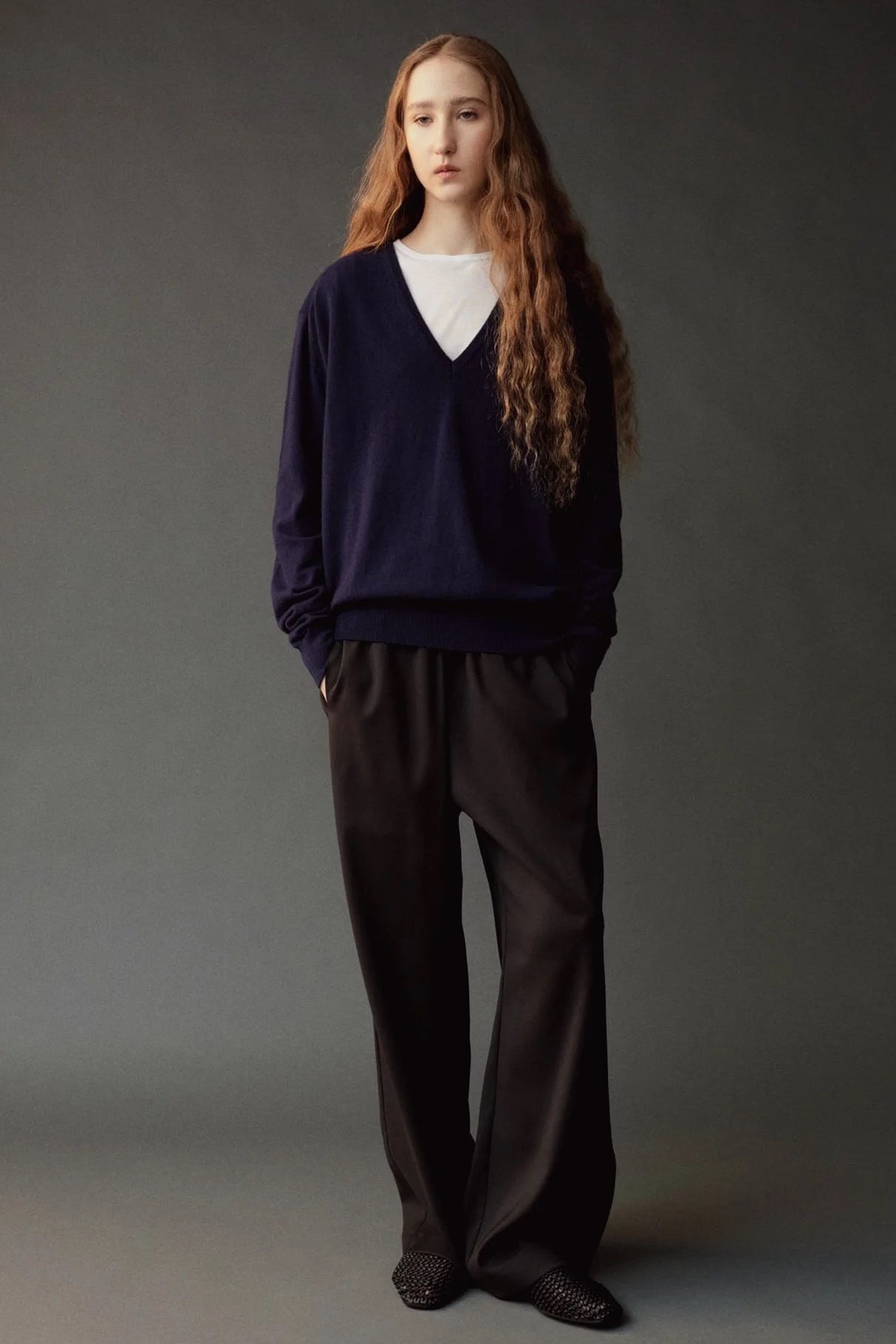 Front view of the Mijeong Park black wool blend pants styled with a navy V neck sweater