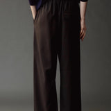 Close back view of the Mijeong Park black pants showing the elastic waist and rear welt pocket
