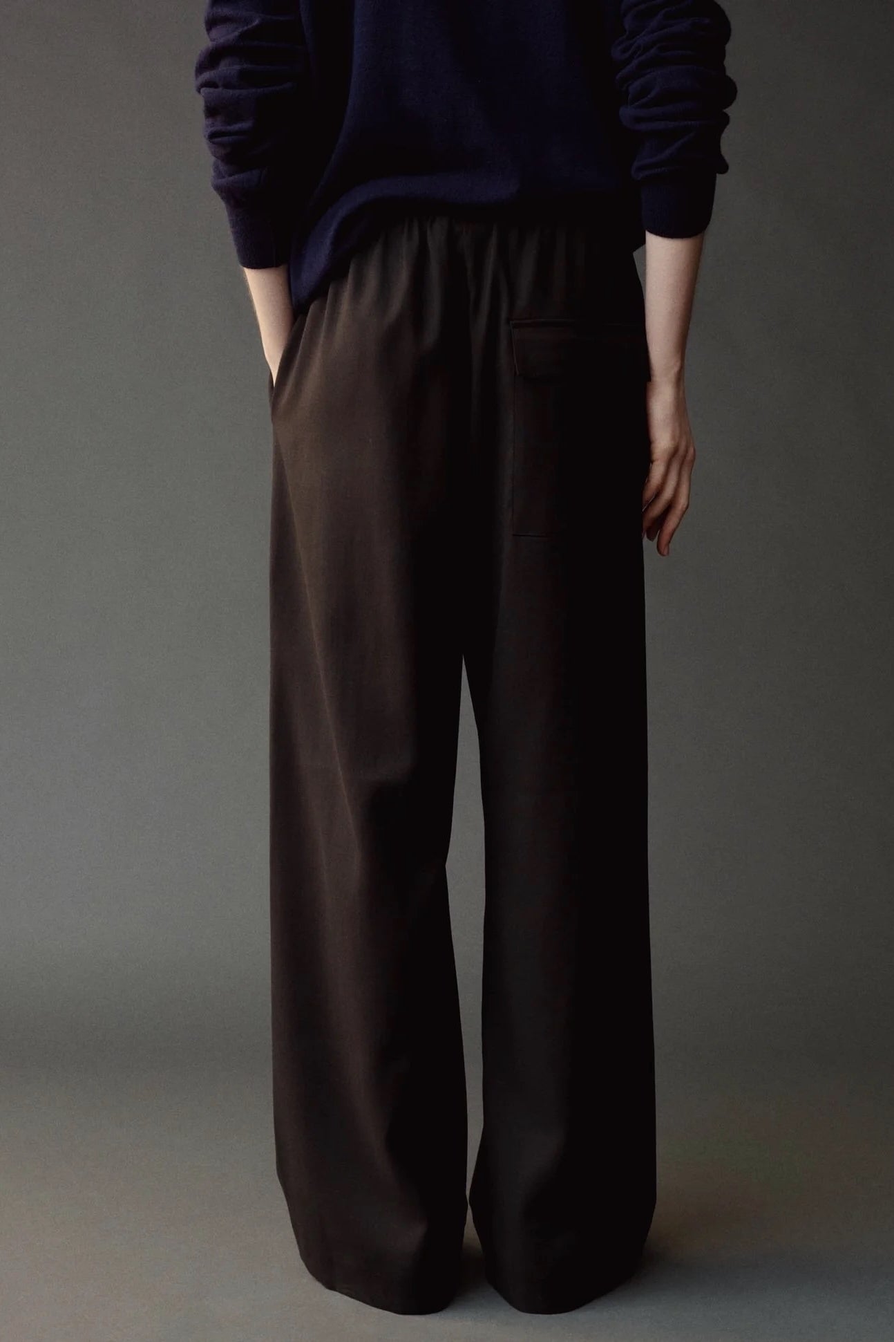 Close back view of the Mijeong Park black pants showing the elastic waist and rear welt pocket