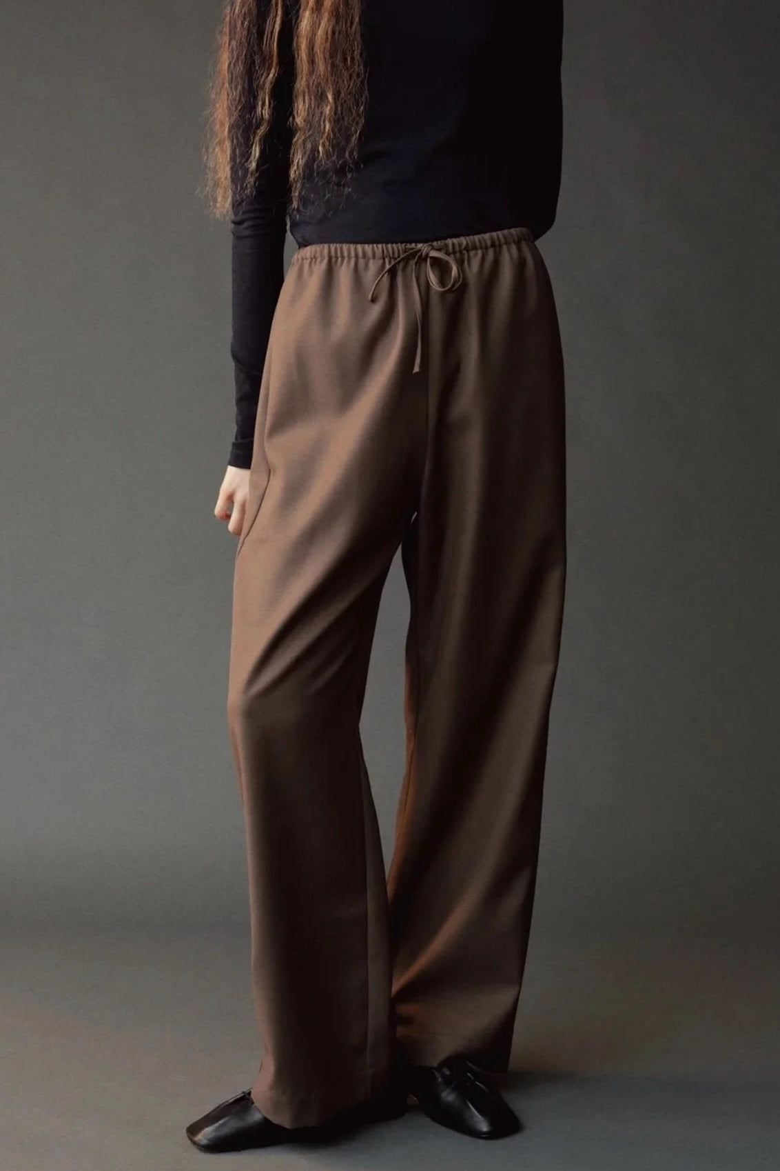Close front view of the Mijeong Park olive brown pants showing the drawstring waist and fluid drape