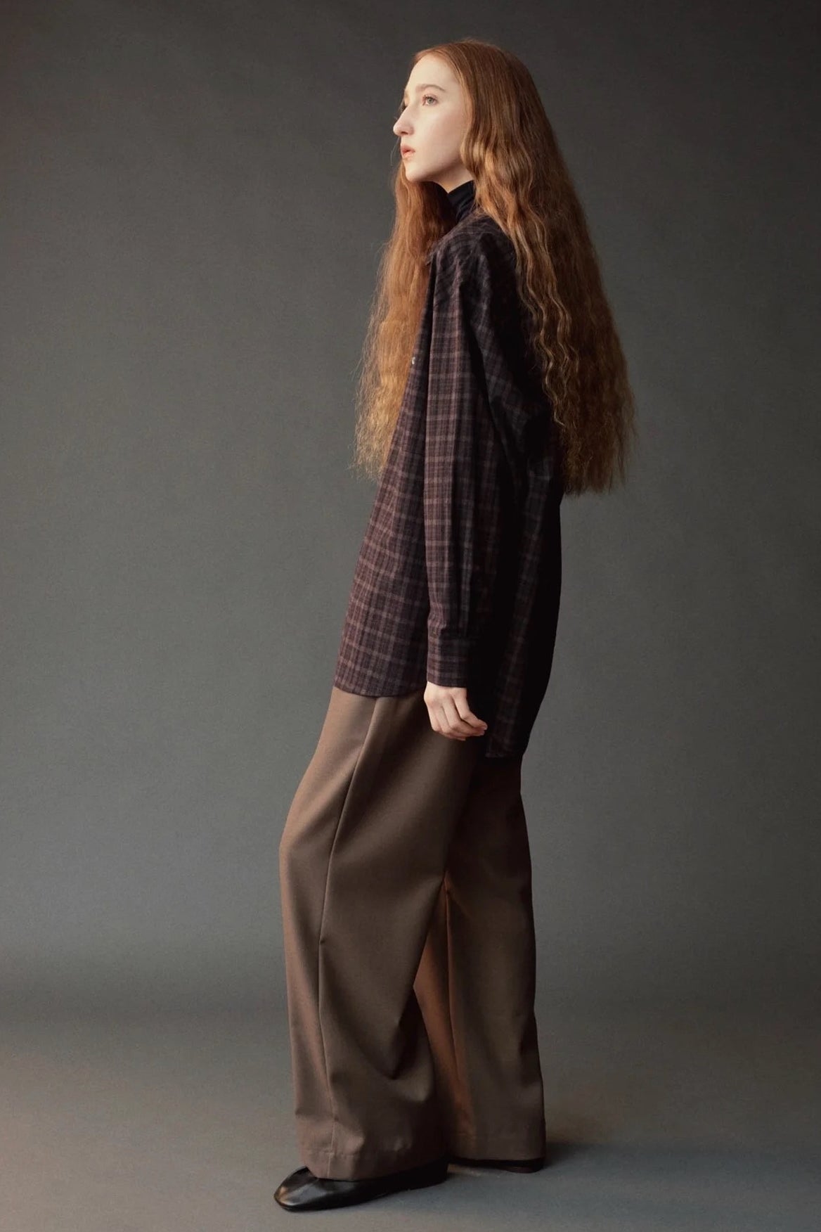 Side view of the Mijeong Park olive brown drawstring pants showing the relaxed wide leg