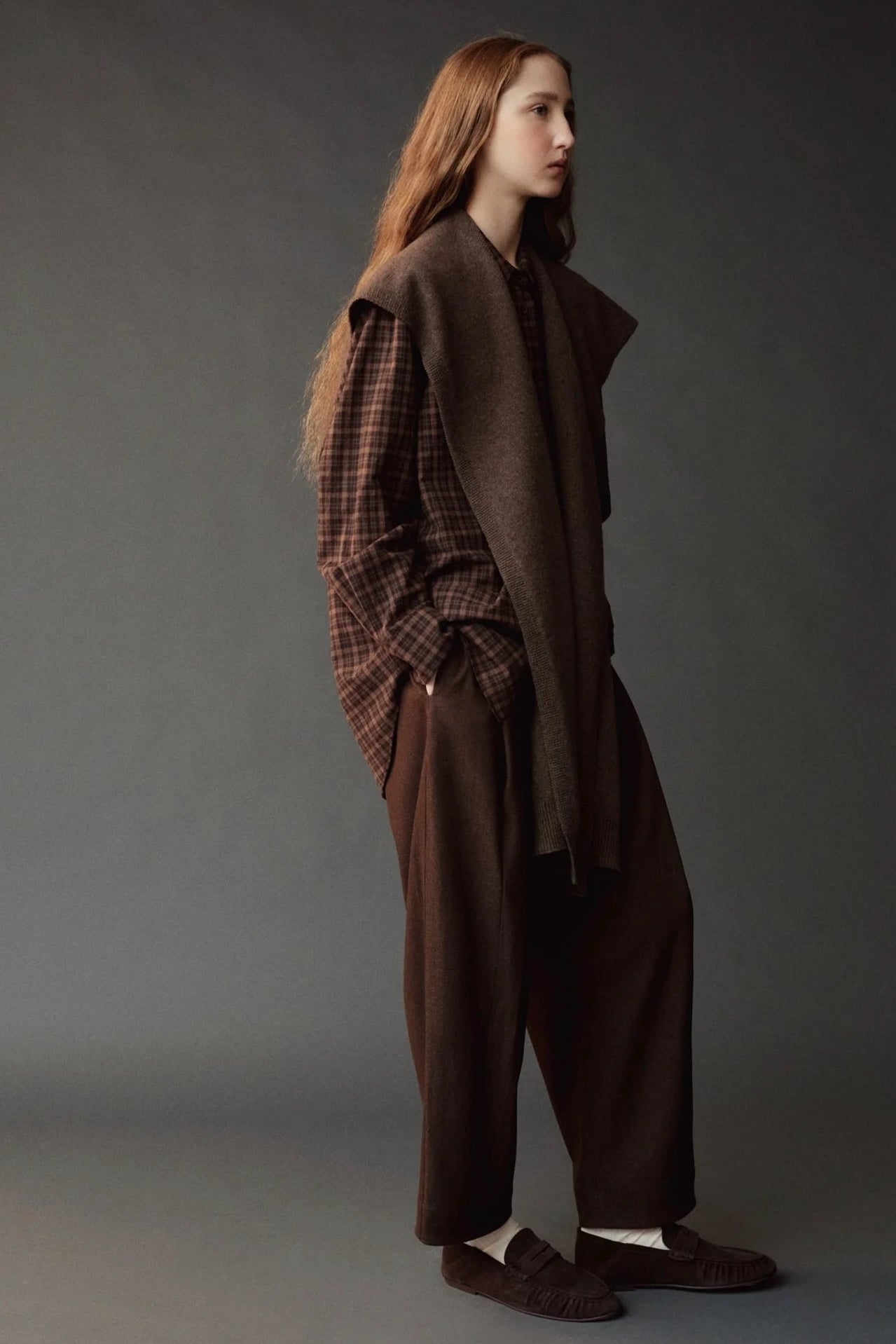 Mijeong Park Wool Blend Knit Shawl Light Brown draped over plaid shirt and brown trousers