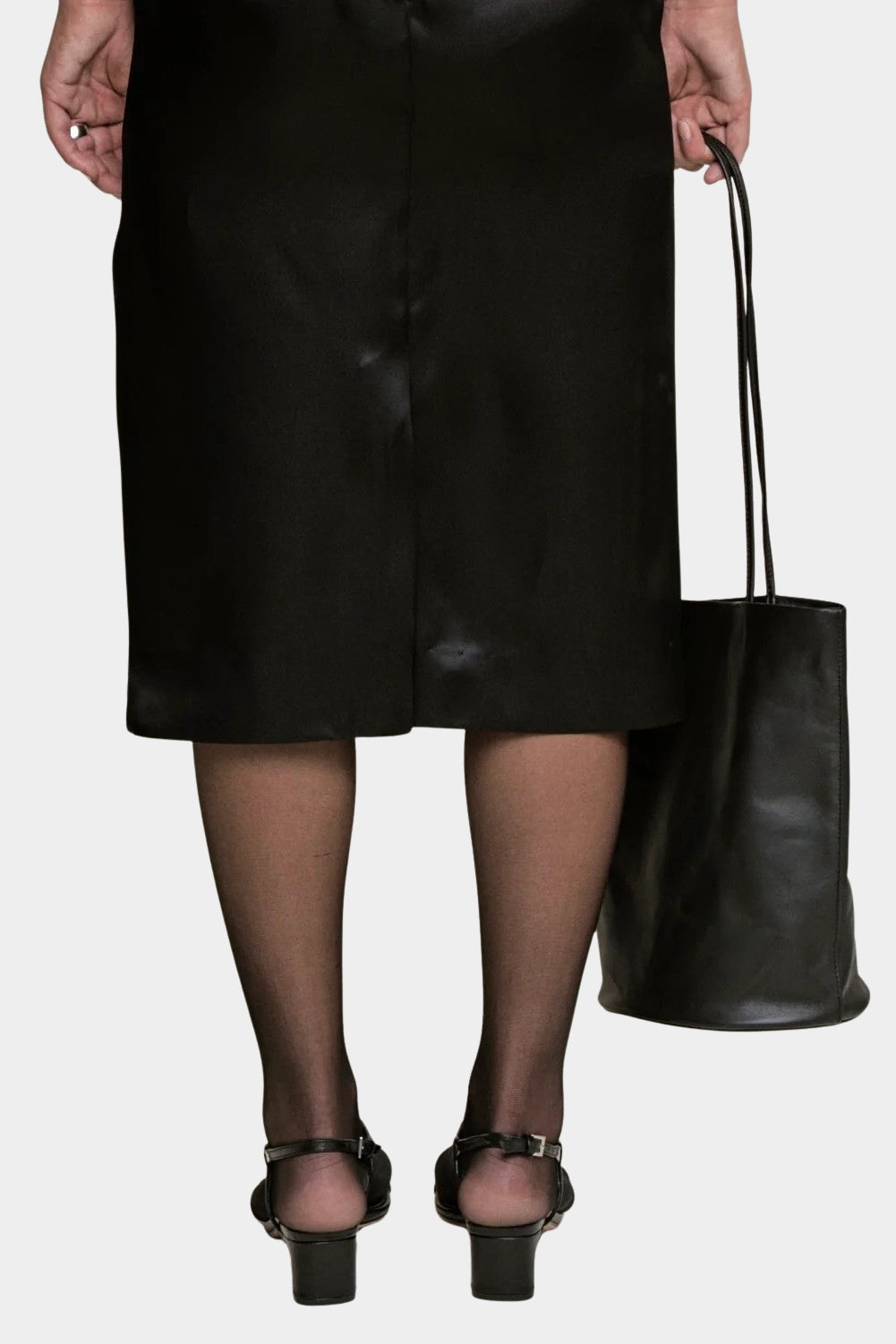 Black Drape Oval Bucket carried by hand with a black skirt and sheer tights