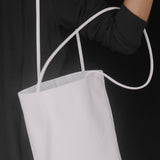Modern Weaving Drape Oval Bucket in Creme carried by its slender straps against a black outfit