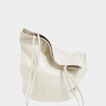 Soft Creme leather Drape Oval Bucket folded to show its drape and slender straps