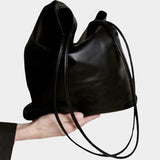 Modern Weaving Slim Elongated Tote Black worn on shoulder showing tall vertical silhouette and slim straps