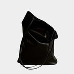 Modern Weaving Slim Elongated Tote Black held by hand highlighting narrow shape and fluid leather drape