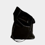 Modern Weaving Slim Elongated Tote Black held by hand highlighting narrow shape and fluid leather drape