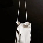 Modern Weaving Slim Elongated Tote Creme held by strap highlighting narrow profile and lightweight structure