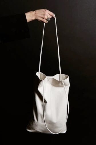 Modern Weaving Slim Elongated Tote Creme held by strap highlighting narrow profile and lightweight structure