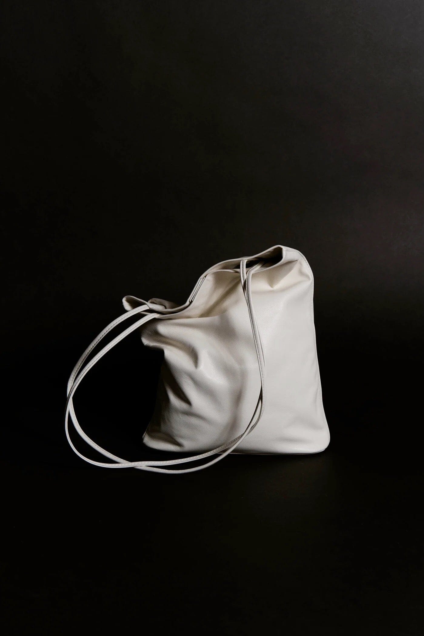 Modern Weaving Slim Elongated Tote Creme on dark background showing structured base and minimal bucket shape