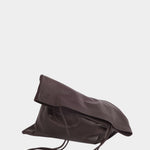Braun leather Slim Lamb Sak lying on its side with its soft upper edge folded over and straps draped in front