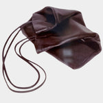 Modern Weaving Slim Lamb Sak in Braun folded on a pale surface, showing its soft leather and long straps
