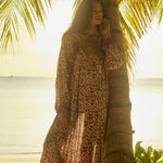 Natalie Martin Fiore Maxi Wildflower Spice resort maxi dress editorial under palm trees at sunset