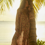 Natalie Martin Fiore Maxi Wildflower Spice resort maxi dress editorial under palm trees at sunset